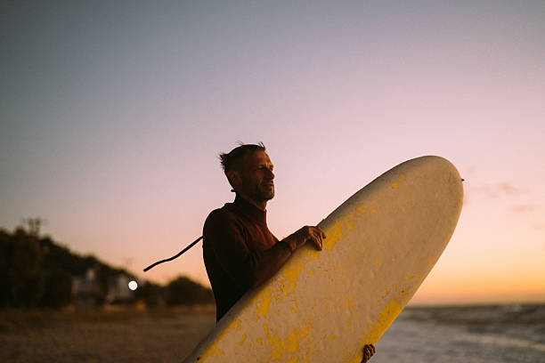istock Male surfer holding his surfboard at the beach 2206879267