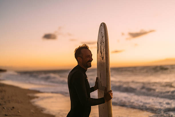 istock Male surfer holding his surfboard at the beach 2206879289