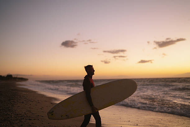 istock Male surfer holding his surfboard at the beach 2206879290