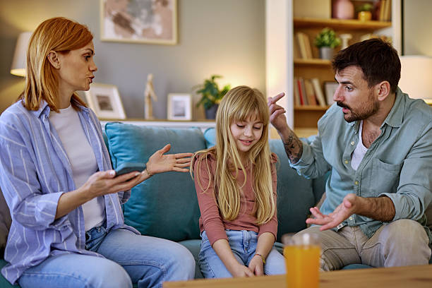 istock Parents arguing while their daughter is sitting between them on the sofa 2206879327