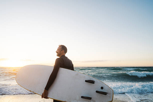 istock Male surfer holding his surfboard at the beach 2206879842