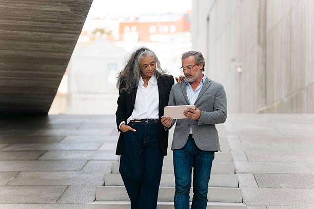 istock Business partners walking and using digital tablet in the city 2206880206