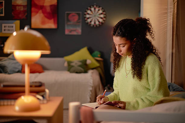 istock Young Woman Studying in Cozy Room with Warm Lighting 2206880383