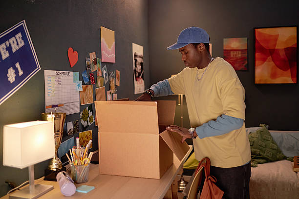 Man Packing Moving Box in Dorm Room