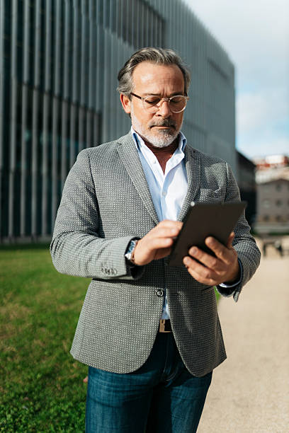 istock Businessman using digital tablet in front of modern office building 2206880744