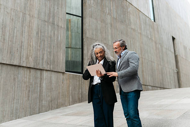 istock Senior business people using digital tablet outdoors 2206881769