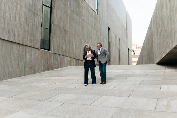 istock Senior businesspeople reading documents outside modern office building 2206881772