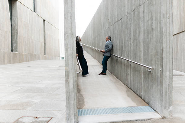 istock Two mature business people talking on a ramp between concrete walls 2206881930