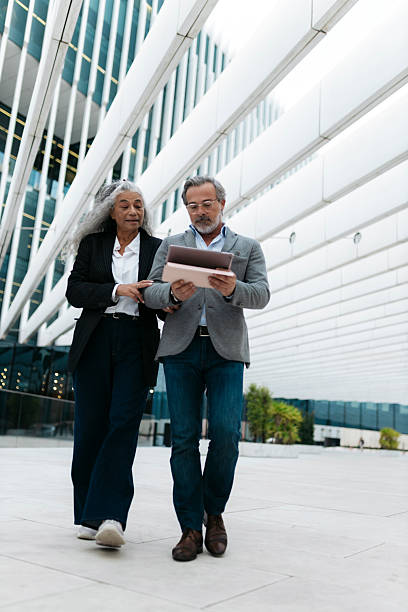 istock Business partners walking and discussing a project using a digital tablet 2206882384