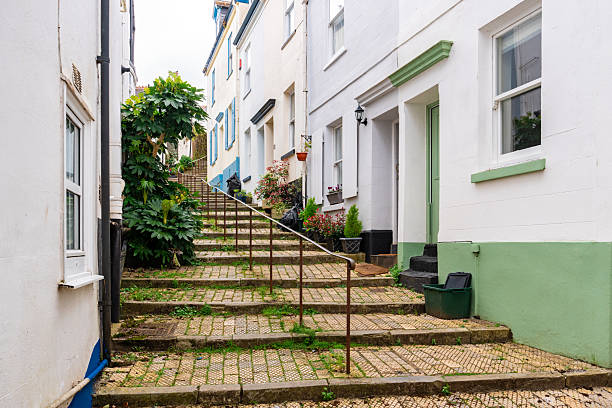 Quaint street scene in the historic coastal town of dartmouth, devon, featuring a steep cobbled street with steps, handrail, and charming houses