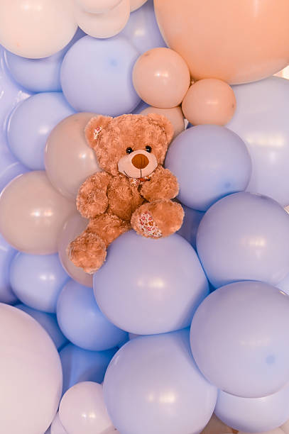 Vertical photo plush bear surrounded by helium balloons makes perfect playful background for kids party filled with laughter and happy memories. teddy bear vibrant party decoration