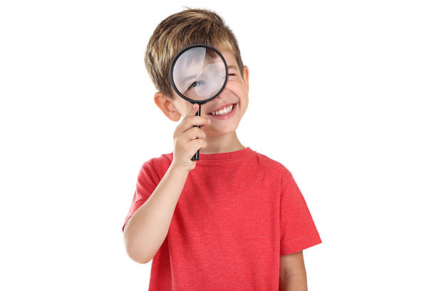 istock Little boy with magnifying glass on white background 2206884639