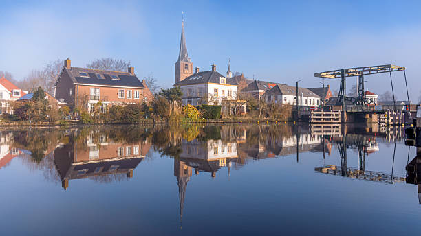 Picturesque Dutch Village Koudekerk aan den rijn,  Reflection in Rhine river on a Clear Morning