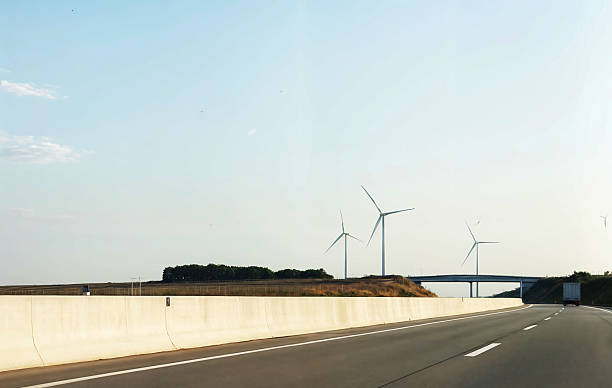 istock Modern landscape with wind turbines, along the road. Tall white structures rotate under the influence of the wind 2206887166