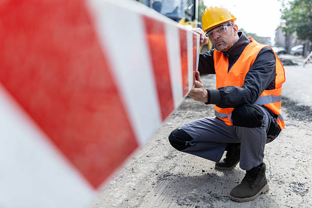 istock Construction worker adjusts safety barrier during roadwork at urban site in midday sun 2206888707