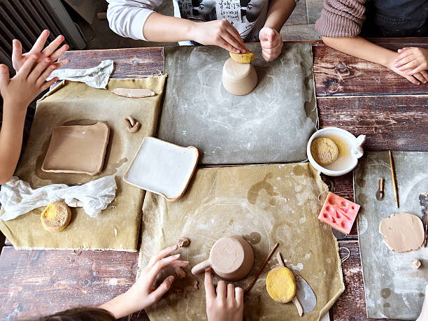 istock Workshop for kids. Children learning how to use clay for making beautiful dishes 2206888913