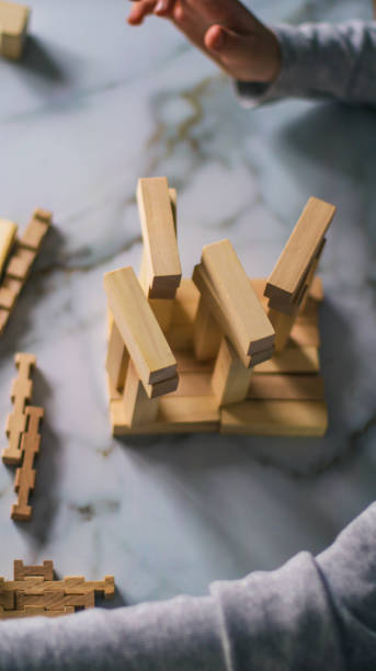 istock blond boy collects wooden puzzle cubes at table in kitchen 2206889973