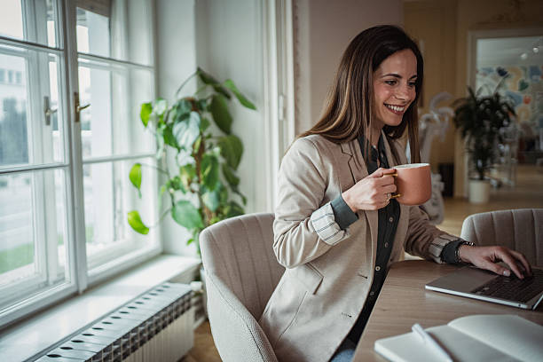 istock Businesswoman working on laptop and drinking coffee in modern office 2206899162