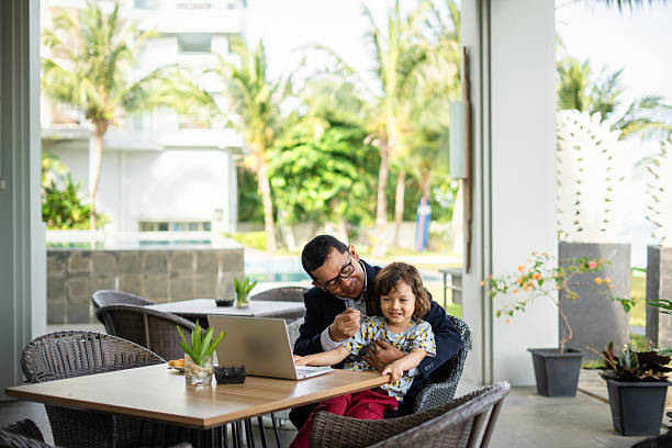 istock Affectionate single father and his small son during meal breakfast  at the hotel table 2206903991