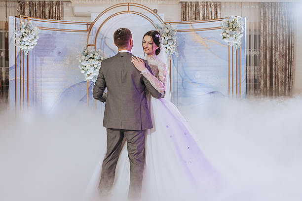 istock A bride and groom are dancing in front of a blue archway 2206906357