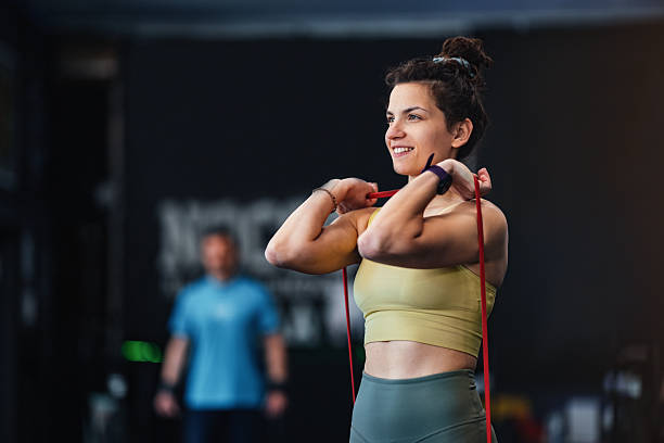 istock Woman Smiling While Exercising Using Resistance Bands in a Gym 2206907280