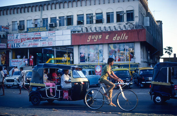 Mumbai, India – March 1, 1986: Street scene, Tuk Tuk in front of Guys and Dolls.