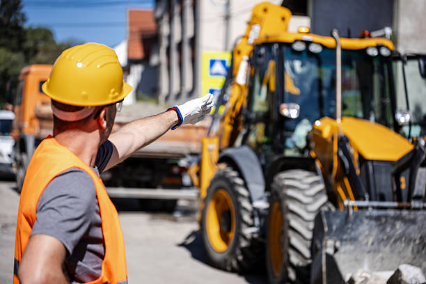 istock Construction worker directing machinery on site during sunny day in urban area 2206907740