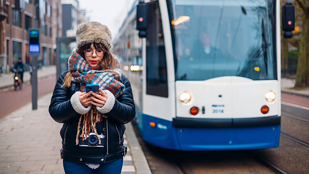 istock Young Woman Using Smartphone Near Public Tram in Urban Setting 2206909336