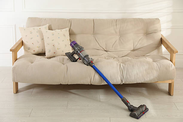 istock One cordless vacuum cleaner leaning on sofa indoors 2206911124