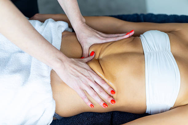 istock Masseuse giving abdominal massage to woman lying on massage table 2206912101