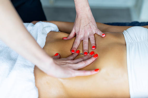 istock Masseuse performing visceral manipulation on patient's abdomen 2206912140