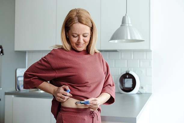 Woman administering a medical injection in a bright home kitchen setting