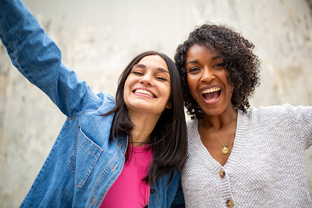 istock happy young women smiling with arms raised 2206918465