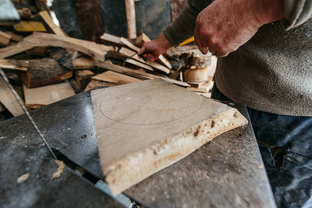 istock Carpenter Cutting Wood with a Bandsaw in a Rustic Workshop 2206924092