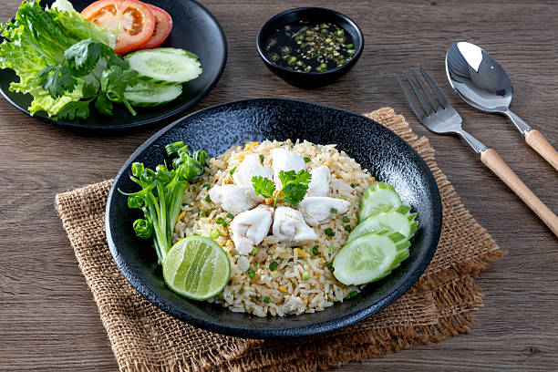 istock Crab fried rice with cucumber and lime on black plate 2206929417