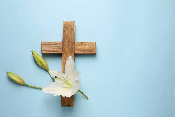 istock Wooden cross and lily flowers on light blue background, top view with space for text. Easter attributes 2206929854