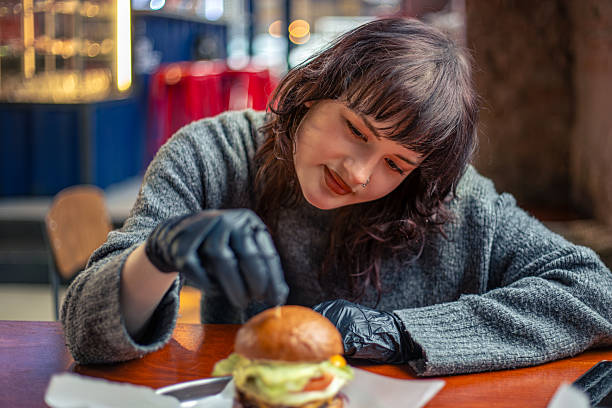 Young woman eating burger. Fast food. Cheat Meal. A woman in a burger restaurant.