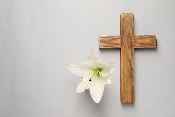 istock Wooden cross and lily flower on grey background, top view with space for text. Easter attributes 2206931795