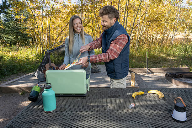 Man and woman happy while cooking at camp in Golden, Colorado, United States