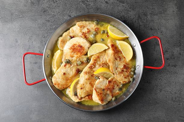 istock Delicious chicken piccata with lemons on grey table, top view 2206937697