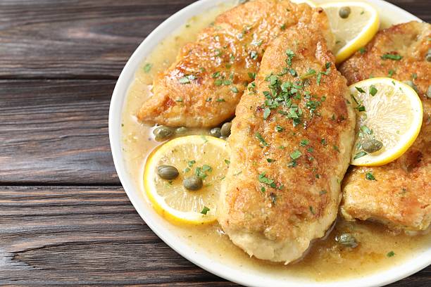 istock Delicious chicken piccata on wooden table, closeup 2206937732