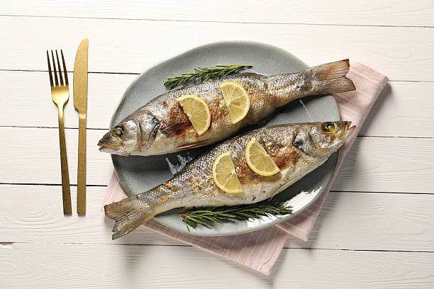 istock Delicious baked fish served on white wooden table, top view 2206937736