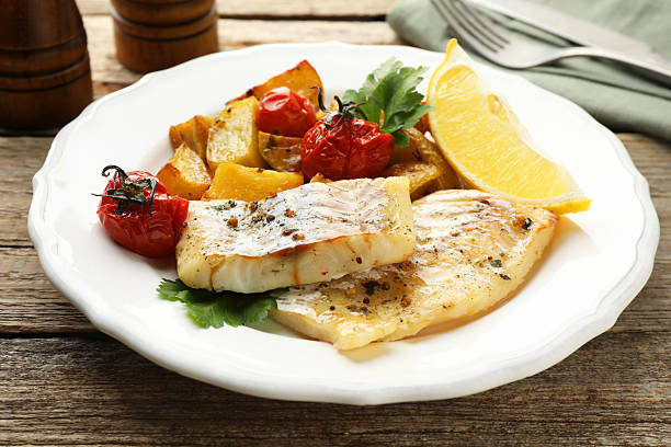 istock Tasty cod cooked with vegetables served on wooden table 2206937861