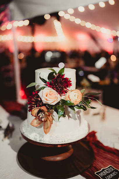 istock Wedding cake in outdoor tent at wedding reception with string lights and flowers 2206939128