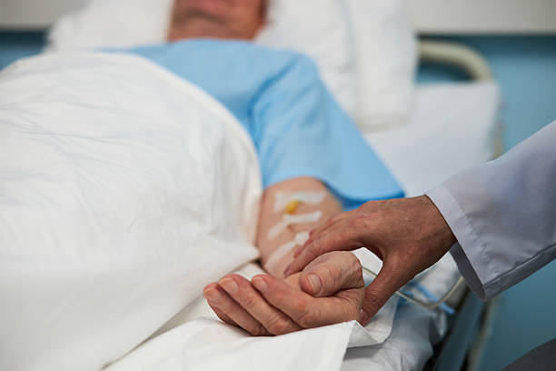 istock Caring for Hospitalized Patient Holding Hand in Bed 2206940037