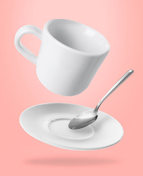 istock Spoon, cup and saucer falling on pink background 2206940557