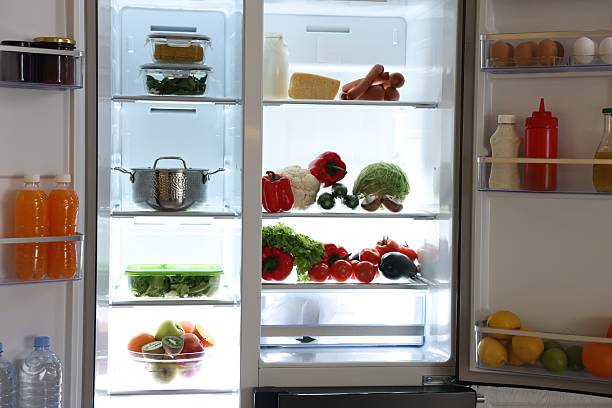 istock Open refrigerator full of different products in kitchen 2206940989