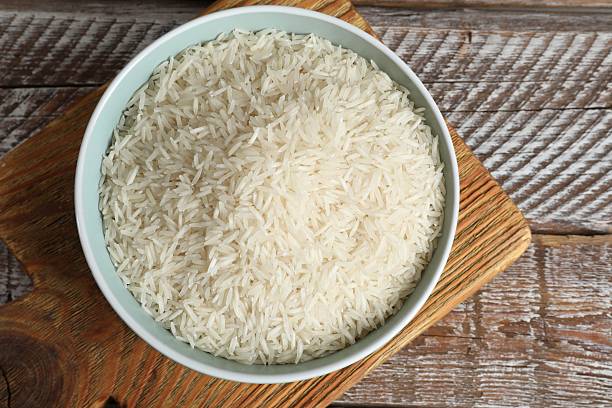 istock Raw basmati rice in bowl on wooden table, top view 2206941632