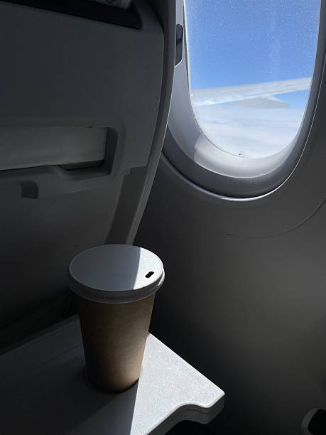 istock Coffee cup on airplane tray table enjoying the view 2206943321