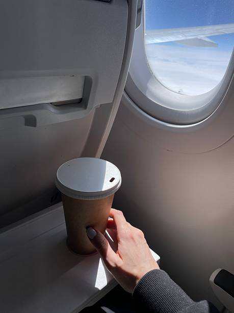 Coffee cup on airplane tray table enjoying the view